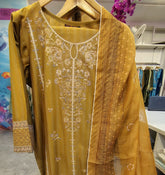 Three-piece embroidered lawn suit from Fashion Street, featuring a traditional design with intricate embroidery and matching fabric pieces.