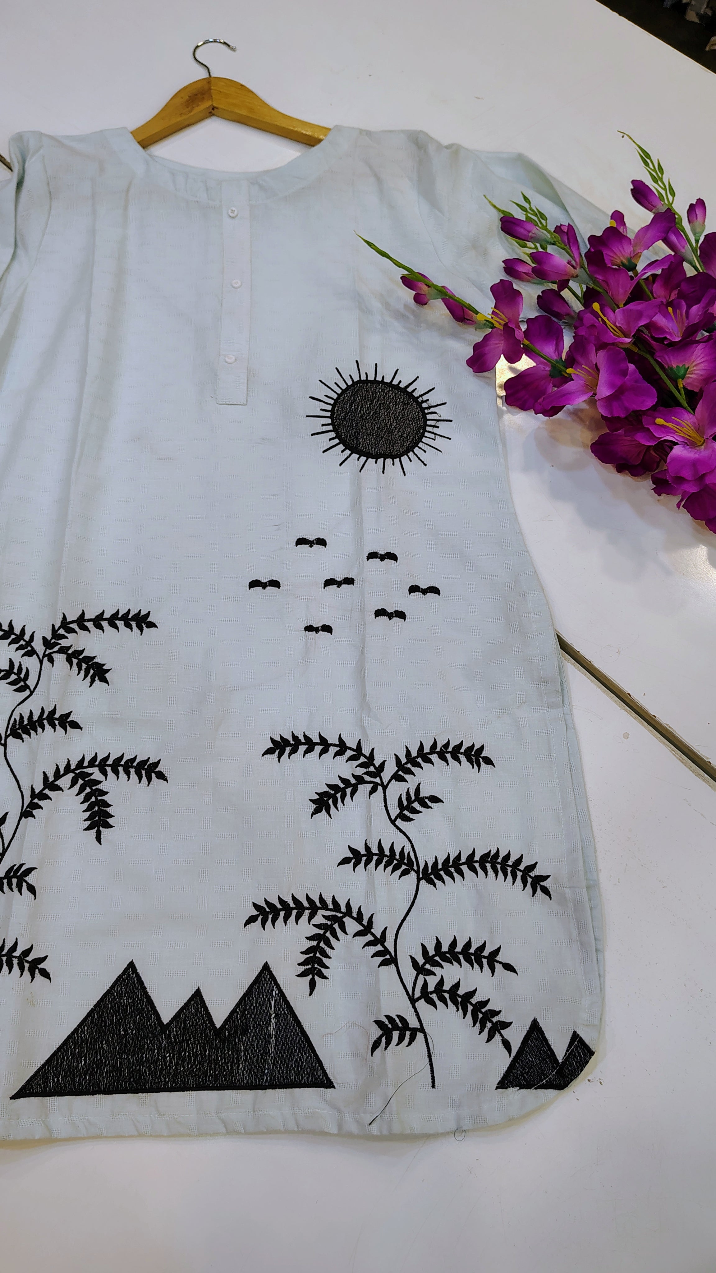 Elegant white embroidered lawn kurta with intricate floral embroidery, perfect for traditional or casual wear.