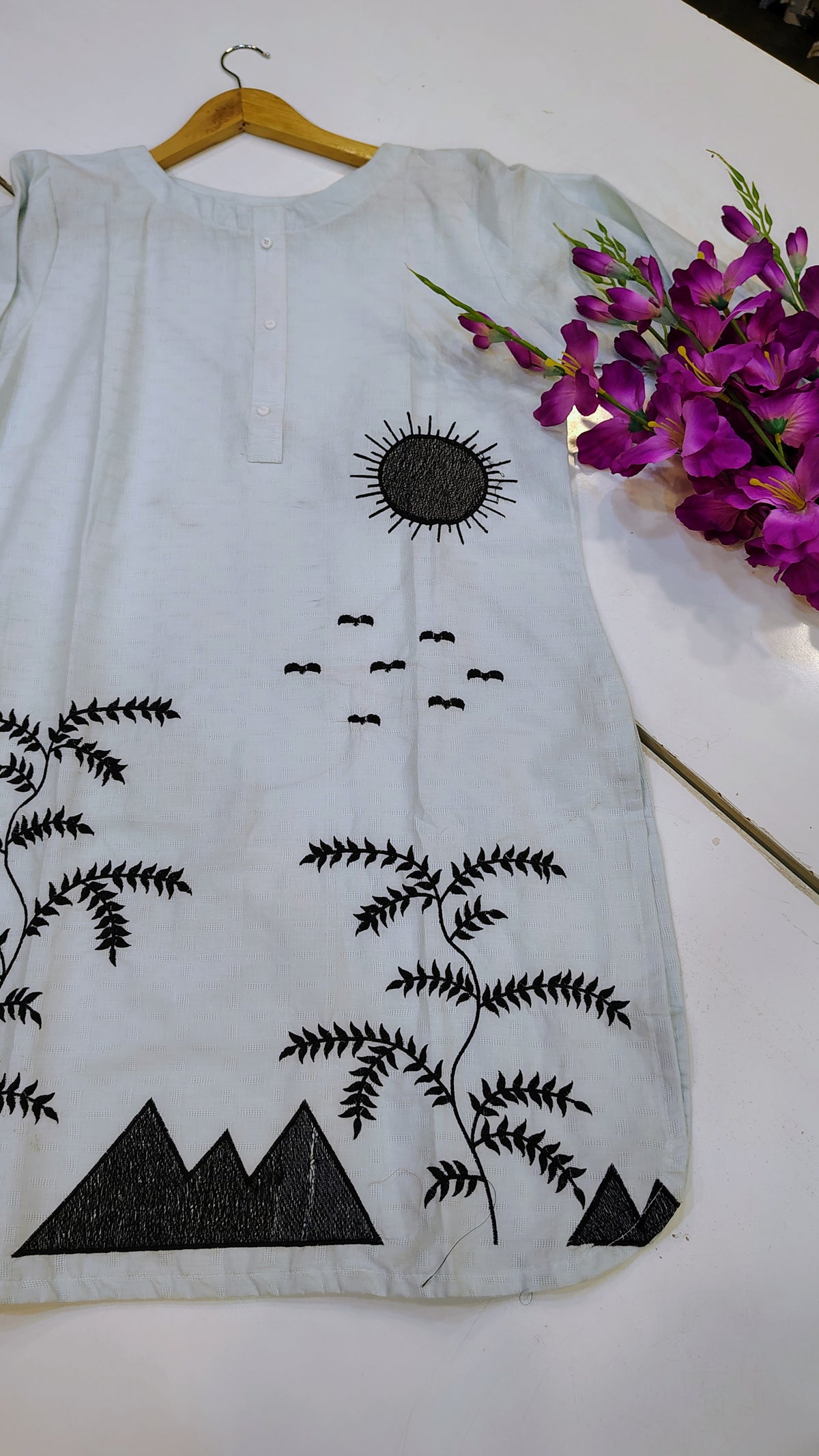 Elegant white embroidered lawn kurta with intricate floral embroidery, perfect for traditional or casual wear.